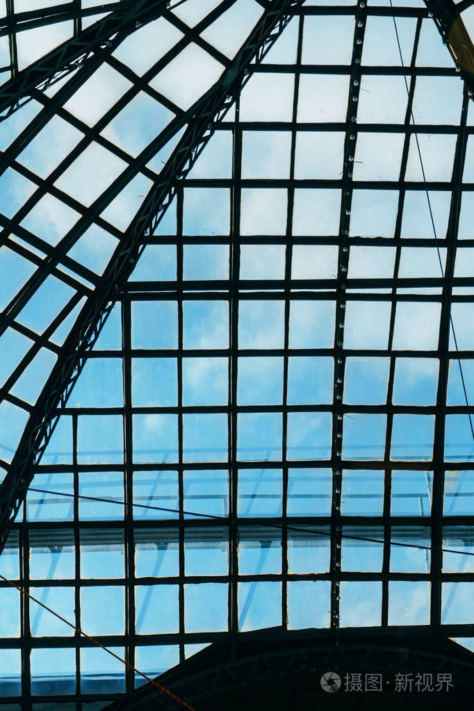 在大城市的大型购物中心和办公楼俯视蓝天的玻璃天花板