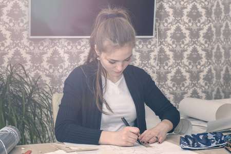 一位年轻女学生的正面画像是在桌子上画素描, 素描, 计划, 建筑。培训和实践