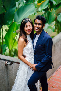 在亚洲, 一个有吸引力的情侣在公园里站在一起。他们正在拍婚礼照片。一个是印度男人, 另一个是中国女人。