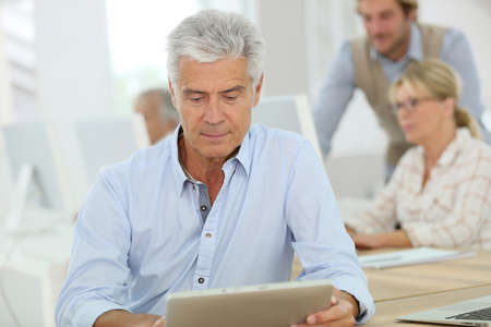 工作老年人老人在平板电脑上工作照片