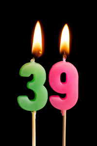 燃烧蜡烛的形式为39三十九 (数字, 日期) 的蛋糕孤立的黑色背景.