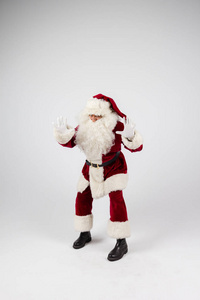 圣诞老人在眼镜和红色服装扔了白色背景上的手，看着相机