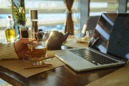 工作喝茶在咖啡喝茶和笔记本电脑上工作的男性为怀照片