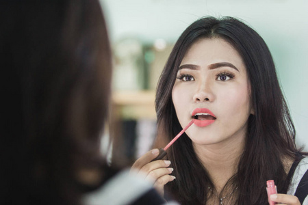 美丽的亚洲女性涂口红照片