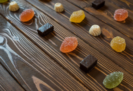 几个五颜六色的甜果酱与巧克力糖果在木桌上