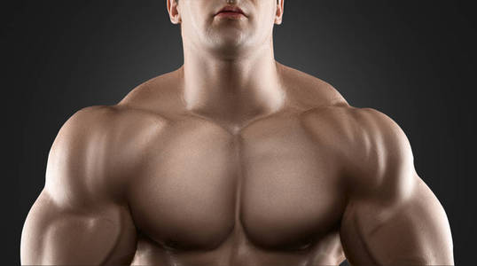 英俊的肌肉健美运动员，构成在黑色的背景
