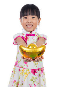 亚洲的中国小女孩穿着旗袍抱着金元宝