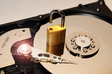 打开硬盘磁盘驱动器表面上的黄金挂锁。数据保护或安全的概念。安全背景