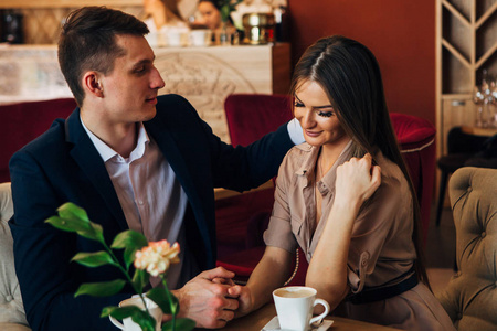 快乐的年轻夫妇带自拍在咖啡馆的智能手机