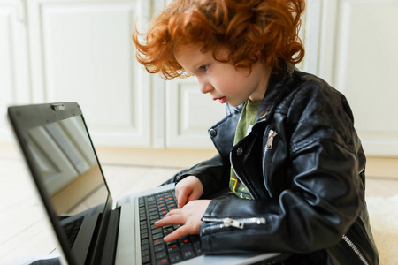小红头发的男孩使用笔记本电脑