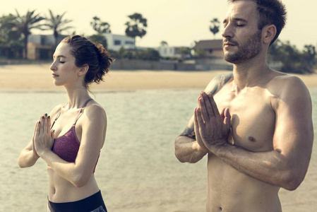 做瑜伽在海滩上的情侣
