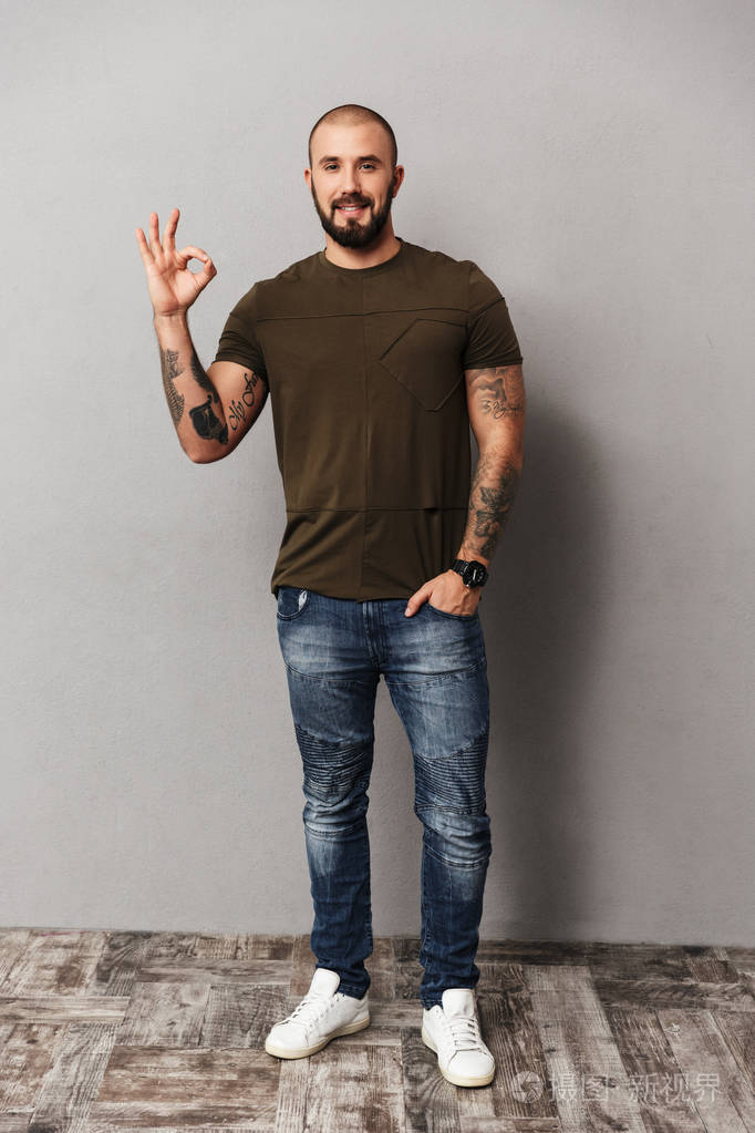 unshaved 光头男子穿着休闲看的全长图像