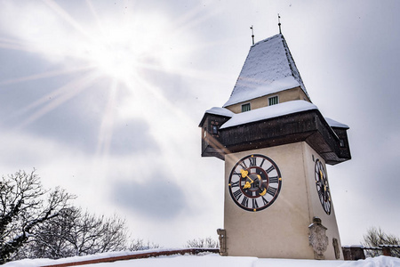 太阳耀斑在雪 Uhrturm 钟楼地标城市格拉茨