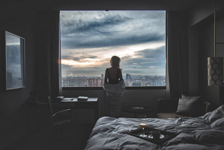 忧郁的早晨在一个旅馆房间以全景对城市照片