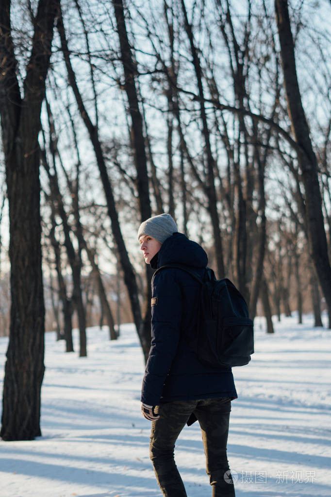 人的侧面在冬季散步的性质和看着肩膀走了