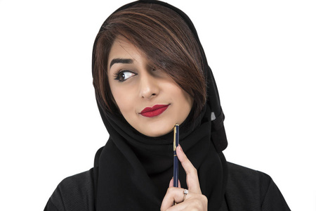 一个阿拉伯年轻的微笑的女人拿着钢笔和思考的肖像