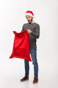 圣诞概念年轻的胡子英俊的男子兴奋打开圣诞老人大袋礼物