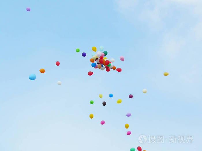 五颜六色的气球在蓝色多云的天空中飞翔