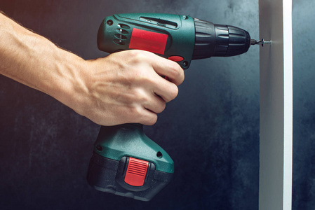 男手拿着螺丝刀,拧紧螺丝男手拿着空白的屏幕智能手机未来锂电池的