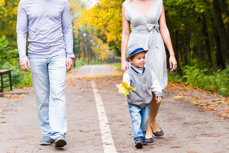年轻的家庭，在婴儿的秋天公园散步