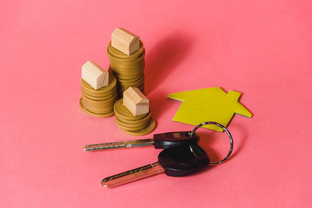 作为抵押和投资概念的微型房子和房子钥匙堆硬币
