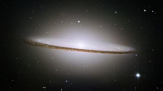 白核被螺旋星系中厚厚的尘道包围着照片