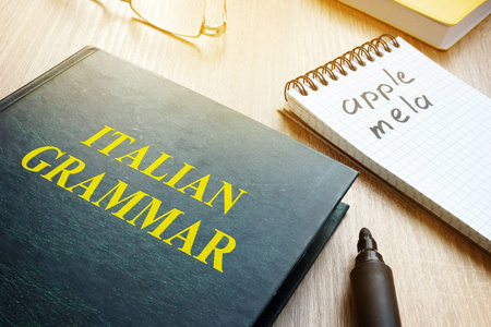 学习意大利语语法。桌子上的书和笔记本