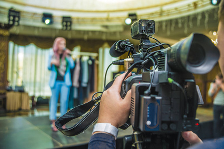 专业操作人员在房间内拍摄视频.电视摄像机照片