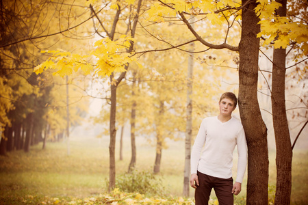 年轻男子在秋天的公园