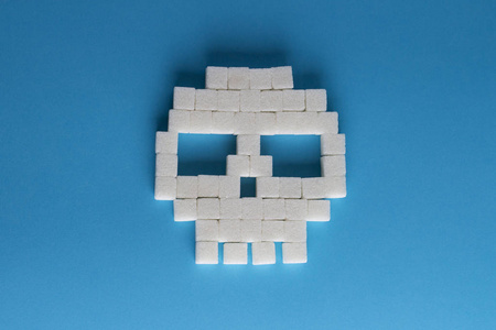 在蓝色背景下的糖和糖块的立方体头骨。T