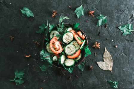 新鲜的沙拉与蔬菜在黑色的哑光背景。健康饮食的概念