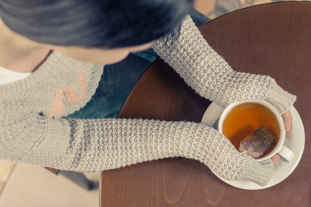 年轻黑发白种女人在酒吧里喝着茶