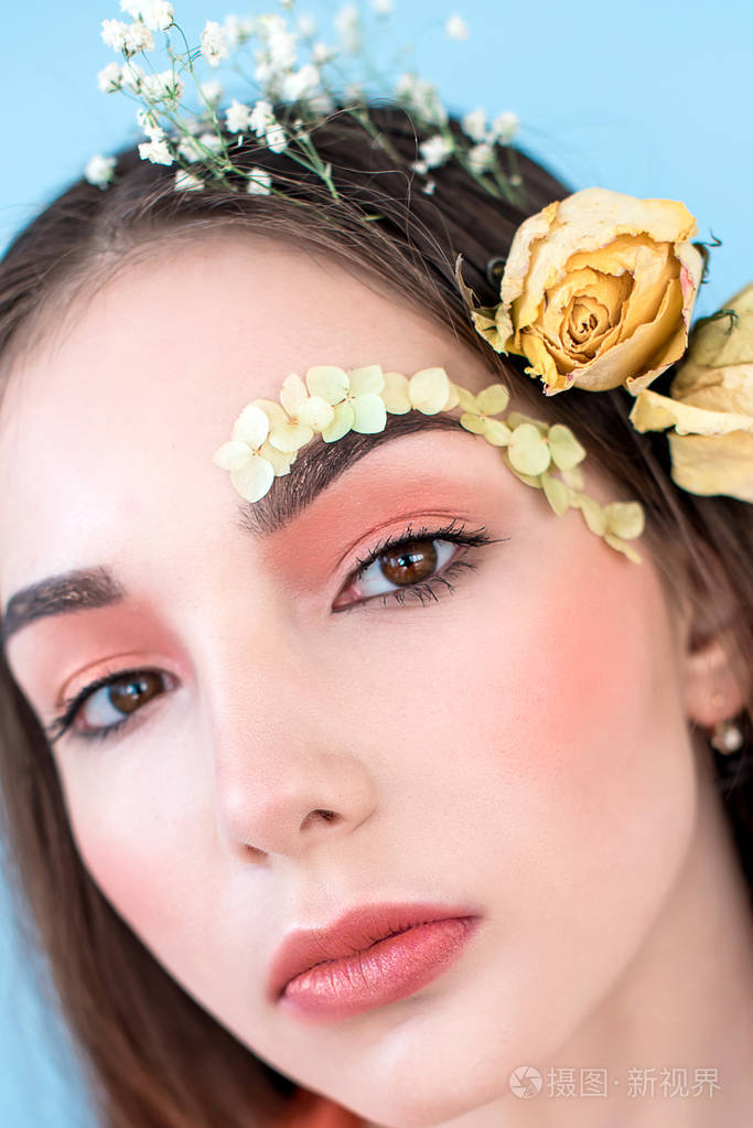 特写肖像的漂亮女人与干燥的花朵在她的脸和头发, 柔和的颜色, 完美的