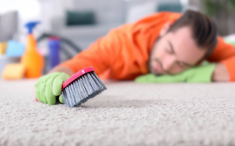 疲惫的人打扫地毯后, 在家地板上睡觉