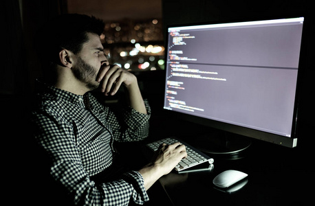 软件开发人员计算机在黑暗的家庭办公室