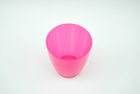白色背景上的粉红色塑料杯