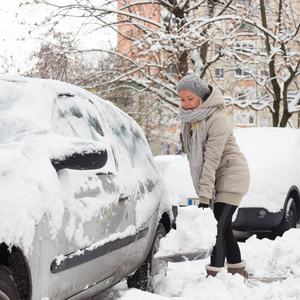 独立的女人在冬天铲雪