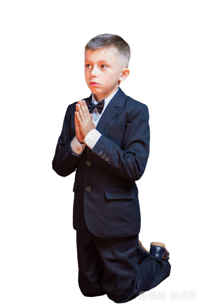 一个穿着西装的小男孩在白色的背景下祈祷