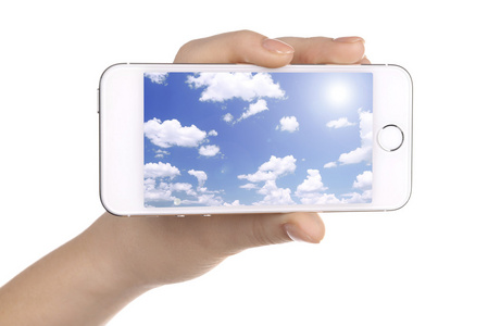 手拿着智能手机与在屏幕中的天空。云计算概念