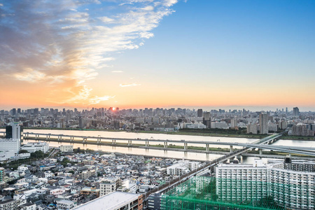 商业与文化的概念   现代城市全景的天际线空中鸟瞰与富士山下戏剧性的晚霞和美丽多云的天空，在东京，日本