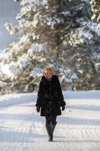 年轻的俄罗斯妇女站在雪地上的道路上冬天