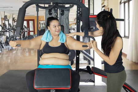 超重妇女在健身房执行运动