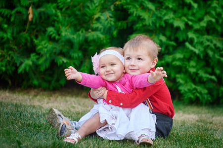 快乐的姐姐和弟弟一起在公园拥抱