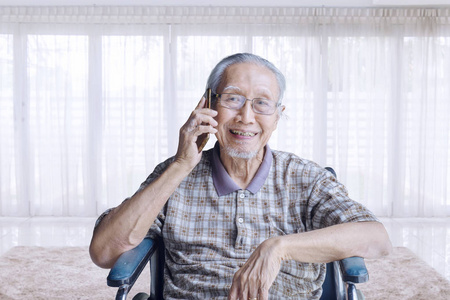 老人在轮椅上与手机通话
