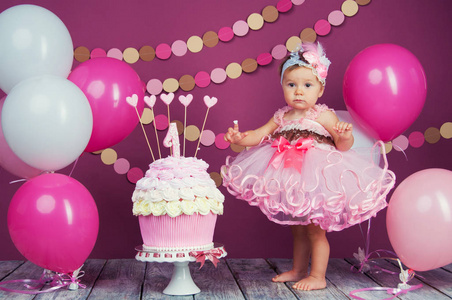 小女孩的生日女孩被涂成了蛋糕。第一个蛋糕。第一个蛋糕的使用。粉碎蛋糕