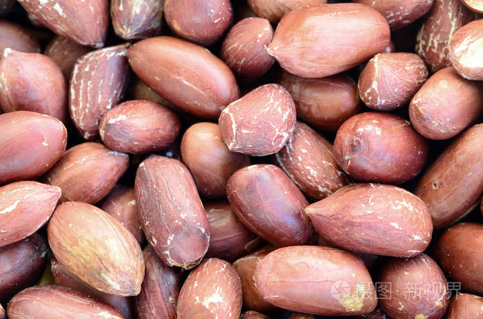 花生.有很多棕色果皮的小黄坚果.背景纹理