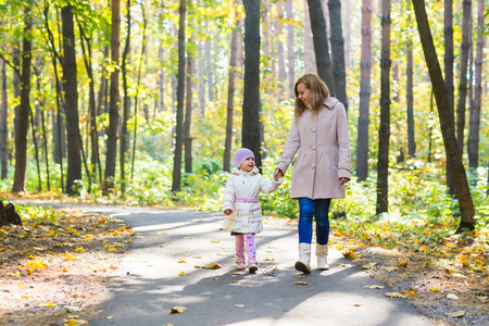 母亲和女儿在秋天的公园