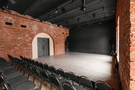 阁楼风格。大厅与黑色椅子的研讨会和会议。一个巨大的房间, 大窗户, 周围的砖砌, 和实木复合地板。为影片和剧院生产