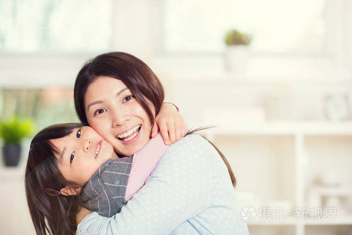 快乐拥抱她可爱的小d的日本母亲的肖像