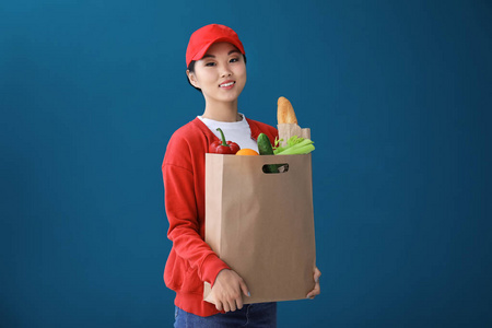 亚洲妇女的产品在纸袋上的颜色背景。食品配送服务